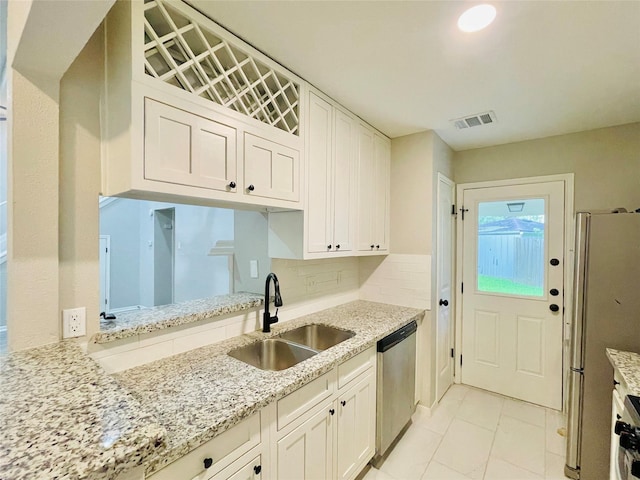 16303 Napa Vine Dr, Houston, TX 77053 - kitchen with stainless steel appliances, a sink, white cabinetry, and backsplash