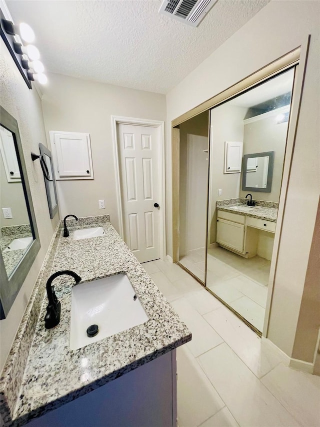 16303 Napa Vine Dr, Houston, TX 77053 - full bathroom featuring double vanity, a textured ceiling, and tile patterned floors