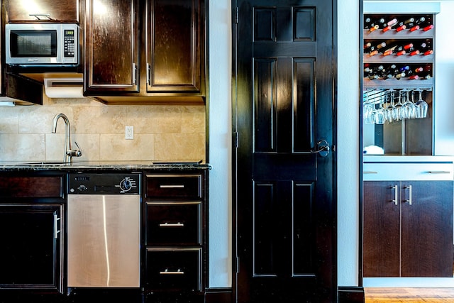 5220 Seawall Blvd Unit 1232, Galveston, TX 77551 - kitchen featuring appliances with stainless steel finishes, a sink, dark brown cabinets, tasteful backsplash, and dark countertops