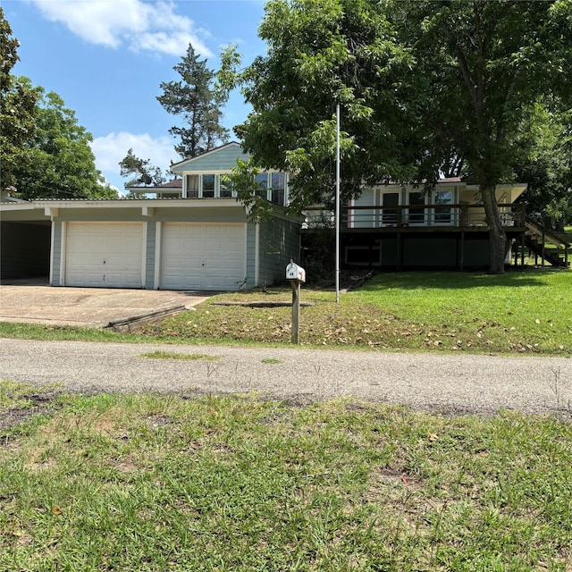 11 Sherry Ln, Coldspring, TX 77331 - view of front of home featuring a front yard, a garage, driveway, and a carport