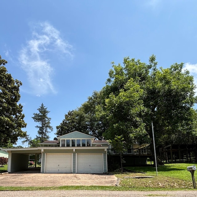 11 Sherry Ln, Coldspring, TX 77331 - view of front facade featuring driveway, a carport, a front yard, and a garage