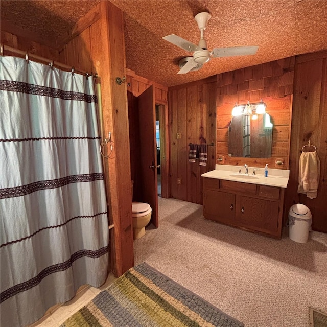 11 Sherry Ln, Coldspring, TX 77331 - bathroom featuring toilet, wooden walls, vanity, a ceiling fan, and a shower with shower curtain