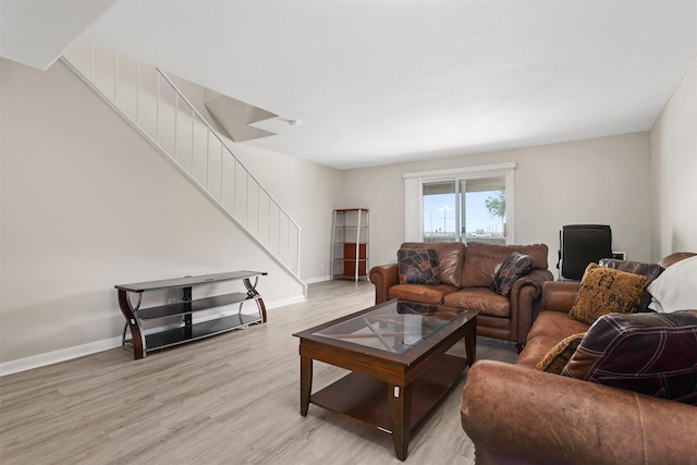 215 Post Office St Unit 1208, Galveston, TX 77550 - living area with stairs, light wood finished floors, and baseboards