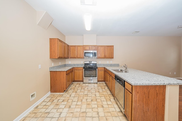 2212 Naomi St, Houston, TX 77054 - kitchen featuring stainless steel appliances, brown cabinetry, a peninsula, and light stone countertops