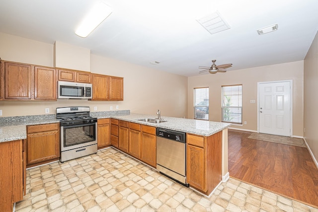 2212 Naomi St, Houston, TX 77054 - kitchen featuring stainless steel appliances, brown cabinets, a peninsula, and a ceiling fan