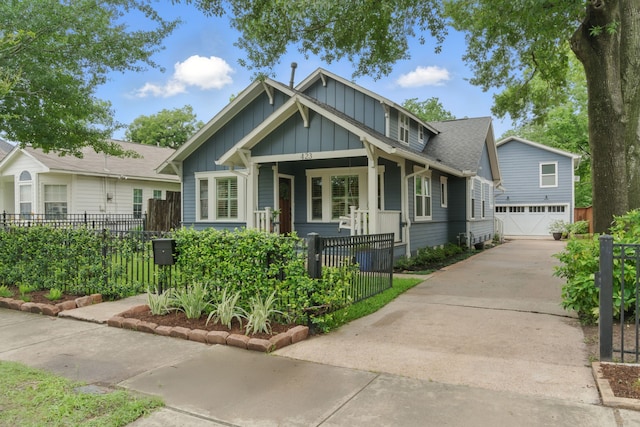 423 Pecore St, Houston, TX 77009 - view of front facade featuring board and batten siding, covered porch, a fenced front yard, driveway, and a garage