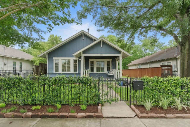 423 Pecore St, Houston, TX 77009 - bungalow-style home with board and batten siding, a fenced front yard, and a gate
