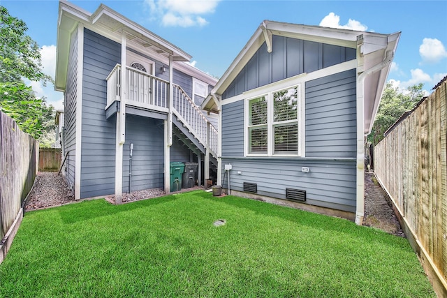 423 Pecore St, Houston, TX 77009 - back of house featuring board and batten siding, a fenced backyard, and stairs