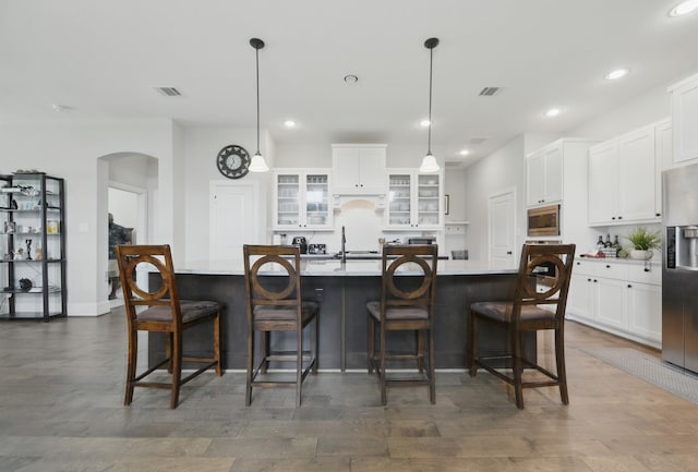 3601 Haskell Hollow Loop, College Station, TX 77845 - kitchen featuring appliances with stainless steel finishes, arched walkways, recessed lighting, a large island, and white cabinetry