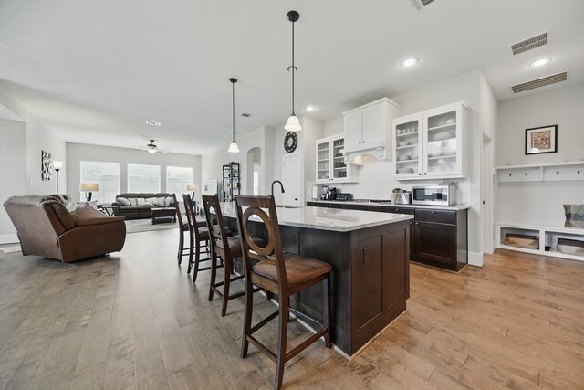 3601 Haskell Hollow Loop, College Station, TX 77845 - kitchen featuring stainless steel appliances, a kitchen breakfast bar, light wood-style flooring, white cabinets, and ceiling fan