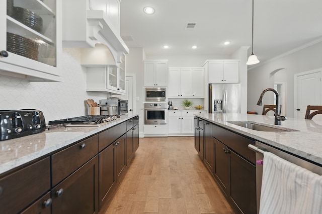3601 Haskell Hollow Loop, College Station, TX 77845 - kitchen with appliances with stainless steel finishes, a sink, white cabinets, dark brown cabinets, and backsplash