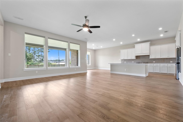 24815 Pavonia Lake Ln, Tomball, TX 77375 - unfurnished living room with plenty of natural light, a ceiling fan, light wood-style flooring, and recessed lighting