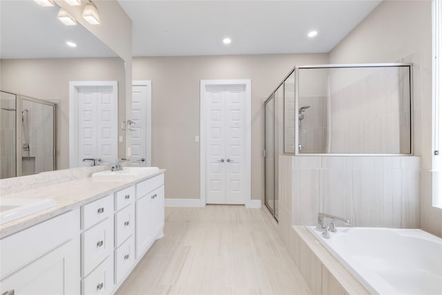 24815 Pavonia Lake Ln, Tomball, TX 77375 - full bathroom featuring double vanity, a shower stall, a bath, a closet, and recessed lighting