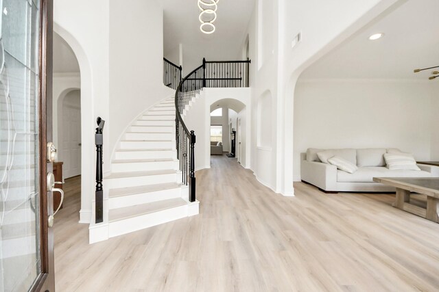 527 Little River Ct, Richmond, TX 77406 - foyer featuring arched walkways, wood finished floors, stairs, baseboards, and a towering ceiling
