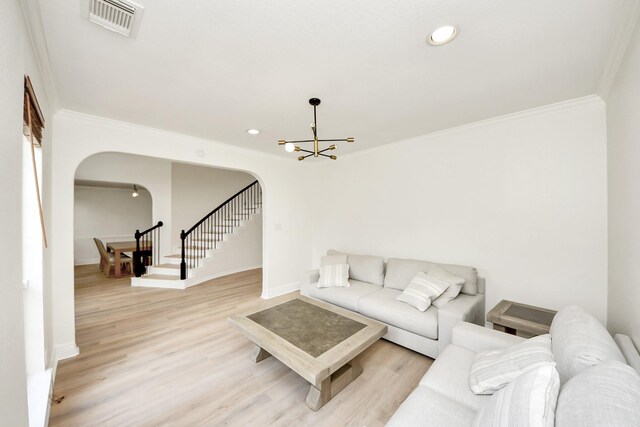 527 Little River Ct, Richmond, TX 77406 - living room featuring arched walkways, crown molding, a chandelier, light wood-type flooring, and baseboards