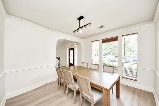 527 Little River Ct, Richmond, TX 77406 - dining area featuring arched walkways, light wood-style flooring, baseboards, and crown molding