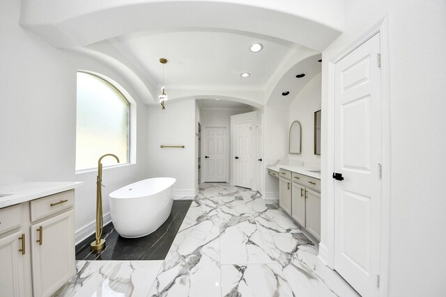 527 Little River Ct, Richmond, TX 77406 - full bathroom featuring vanity, recessed lighting, a freestanding tub, marble finish floors, and baseboards