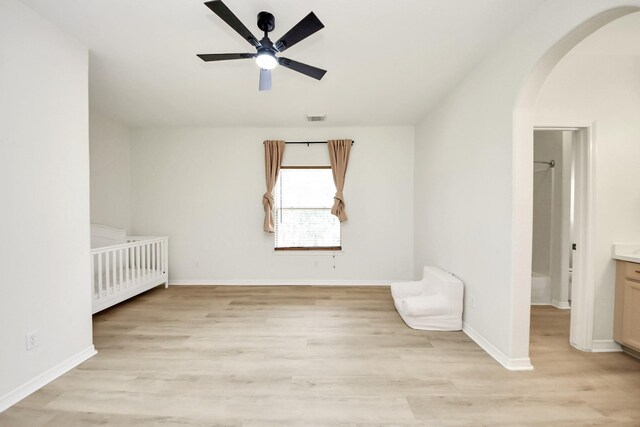 527 Little River Ct, Richmond, TX 77406 - unfurnished bedroom with arched walkways, light wood-style floors, baseboards, and a ceiling fan