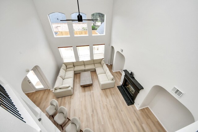 527 Little River Ct, Richmond, TX 77406 - living area with a towering ceiling, light wood-type flooring, plenty of natural light, a fireplace, and a ceiling fan