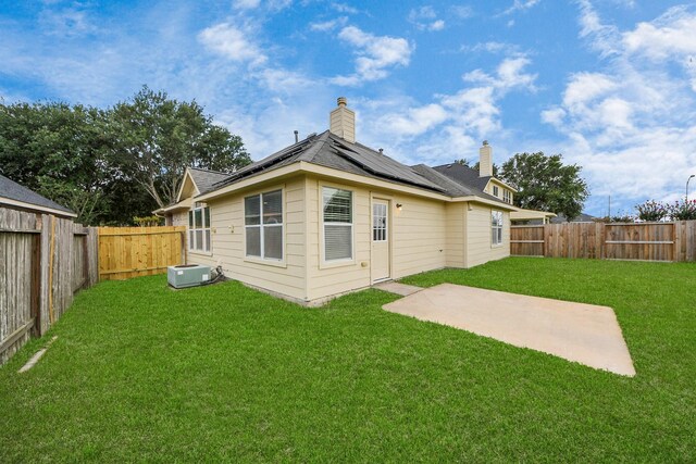 527 Little River Ct, Richmond, TX 77406 - back of house with solar panels, a chimney, a patio, and central AC