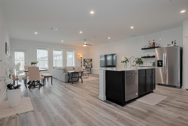 12319 Brandenburg Gate Dr, Houston, TX 77047 - kitchen featuring stainless steel appliances, light countertops, open shelves, light wood-style flooring, and open floor plan