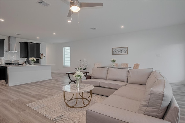 12319 Brandenburg Gate Dr, Houston, TX 77047 - living area featuring light wood finished floors, ceiling fan, recessed lighting, and baseboards