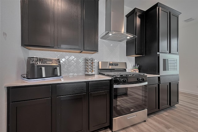 12319 Brandenburg Gate Dr, Houston, TX 77047 - kitchen featuring stainless steel range with gas stovetop, wall chimney range hood, backsplash, and light countertops