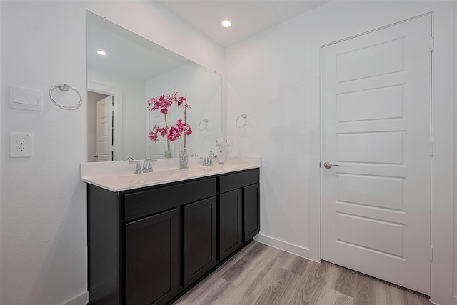 12319 Brandenburg Gate Dr, Houston, TX 77047 - bathroom featuring double vanity, wood finished floors, baseboards, and recessed lighting