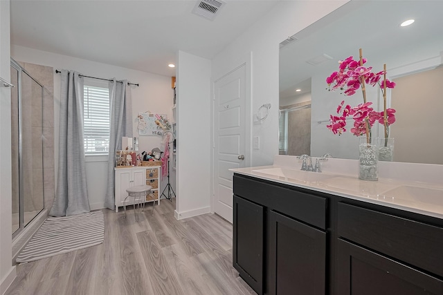 12319 Brandenburg Gate Dr, Houston, TX 77047 - bathroom with a stall shower, wood finished floors, double vanity, recessed lighting, and baseboards