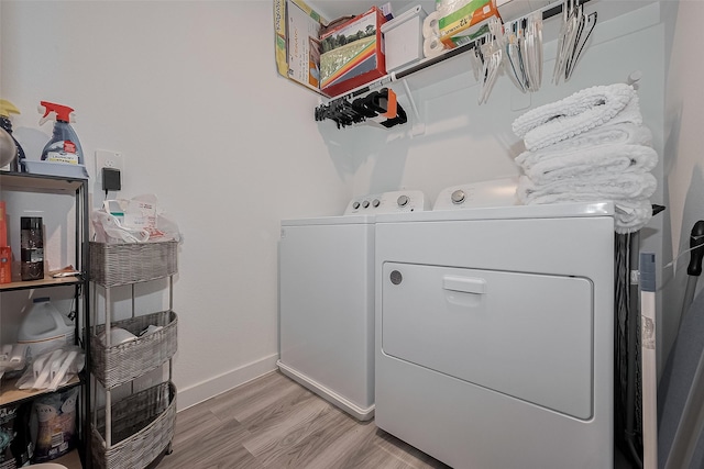 12319 Brandenburg Gate Dr, Houston, TX 77047 - washroom featuring washing machine and dryer, light wood-type flooring, and baseboards
