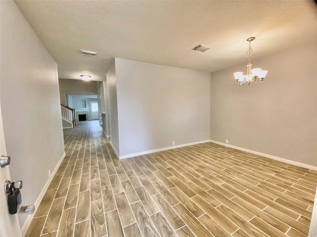 17419 Prospect Meadows Dr, Houston, TX 77095 - unfurnished room with wood finished floors, stairway, baseboards, and a chandelier