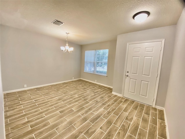 17419 Prospect Meadows Dr, Houston, TX 77095 - entryway with a textured ceiling, wood finished floors, baseboards, and a chandelier