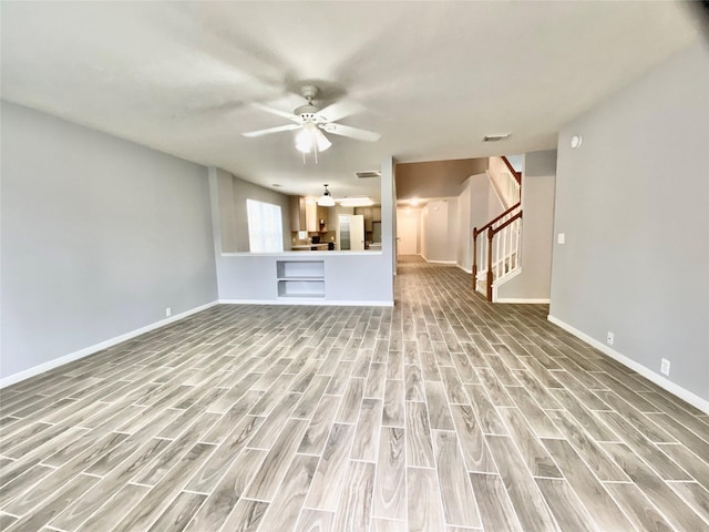 17419 Prospect Meadows Dr, Houston, TX 77095 - unfurnished living room featuring light wood finished floors, baseboards, stairway, and ceiling fan