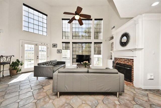 7923 Vintage Creek Dr, Spring, TX 77379 - living area with a brick fireplace, ceiling fan, baseboards, a high ceiling, and french doors