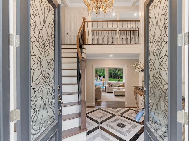 23226 Oak Hollow Ln, Tomball, TX 77377 - foyer featuring inlaid floor details, crown molding, stairs, a chandelier, and baseboards