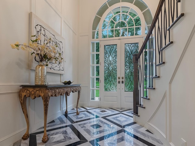23226 Oak Hollow Ln, Tomball, TX 77377 - entryway with a decorative wall, stairway, inlaid floor details, baseboards, and french doors