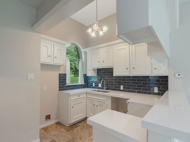 23226 Oak Hollow Ln, Tomball, TX 77377 - kitchen with a sink, decorative backsplash, a chandelier, and white cabinetry