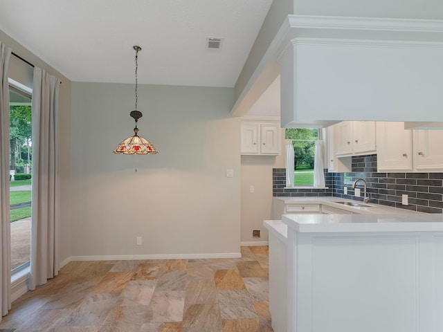 23226 Oak Hollow Ln, Tomball, TX 77377 - kitchen with a sink, decorative backsplash, light countertops, a peninsula, and white cabinets