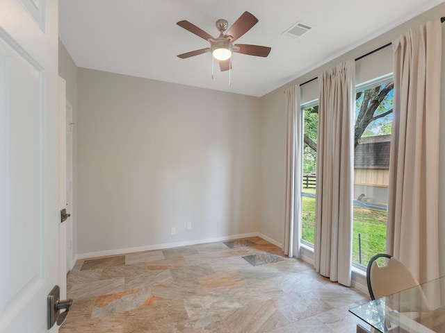 23226 Oak Hollow Ln, Tomball, TX 77377 - spare room with light stone finish floors, plenty of natural light, ceiling fan, and baseboards