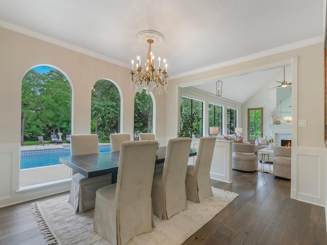 23226 Oak Hollow Ln, Tomball, TX 77377 - dining area featuring a chandelier, wood-type flooring, a warm lit fireplace, wainscoting, and a ceiling fan