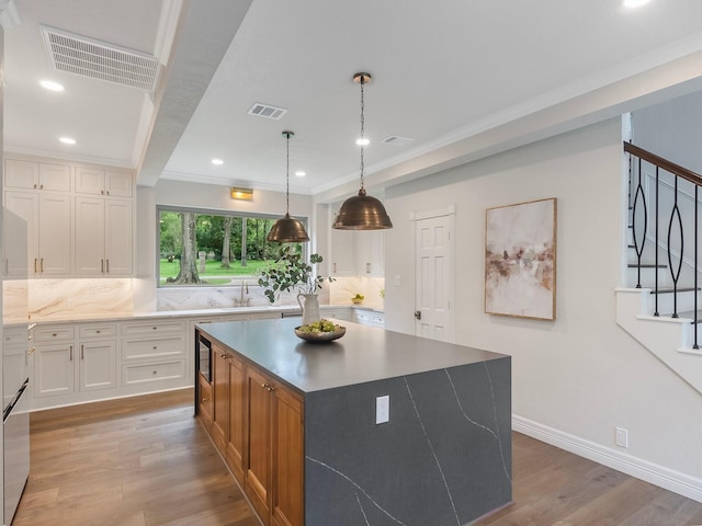 23226 Oak Hollow Ln, Tomball, TX 77377 - kitchen with light wood-style flooring, tasteful backsplash, a kitchen island, white cabinets, and recessed lighting