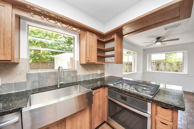 2302 Sun Spring Ct, Spring, TX 77373 - kitchen featuring oven, stainless steel gas stovetop, a sink, a peninsula, and backsplash
