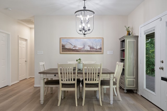 11402 Willis Waukegan Rd, Conroe, TX 77303 - dining room with light wood-type flooring, a chandelier, and baseboards