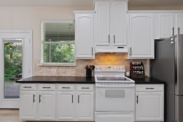 11402 Willis Waukegan Rd, Conroe, TX 77303 - kitchen featuring white electric range, under cabinet range hood, freestanding refrigerator, dark countertops, and white cabinetry