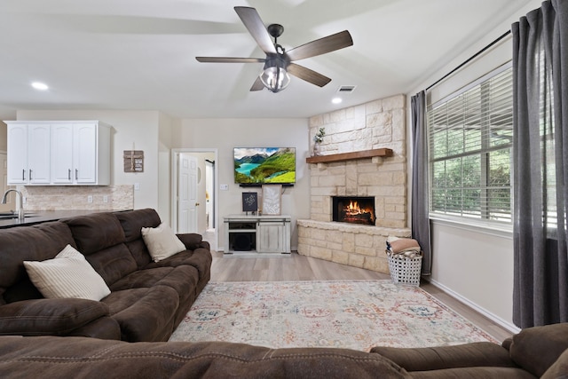 11402 Willis Waukegan Rd, Conroe, TX 77303 - living area with a stone fireplace, a ceiling fan, light wood-type flooring, baseboards, and recessed lighting