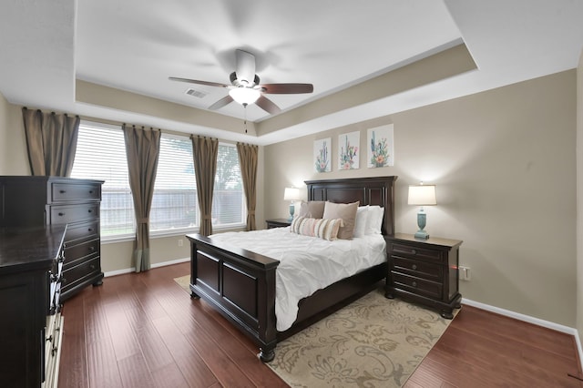 20530 Saddleback Chase Ln, Cypress, TX 77433 - bedroom featuring baseboards, a tray ceiling, dark wood-style floors, and ceiling fan