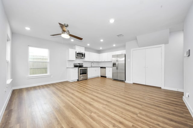 6617 Bacher St, Houston, TX 77028 - unfurnished living room featuring a ceiling fan, baseboards, light wood-style flooring, recessed lighting, and a sink