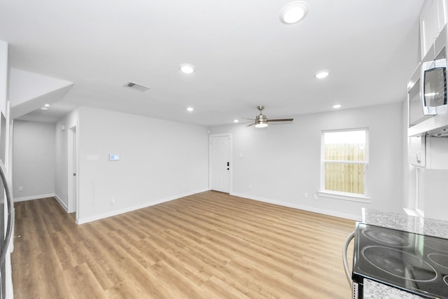 6617 Bacher St, Houston, TX 77028 - unfurnished living room featuring ceiling fan, baseboards, light wood-style flooring, and recessed lighting
