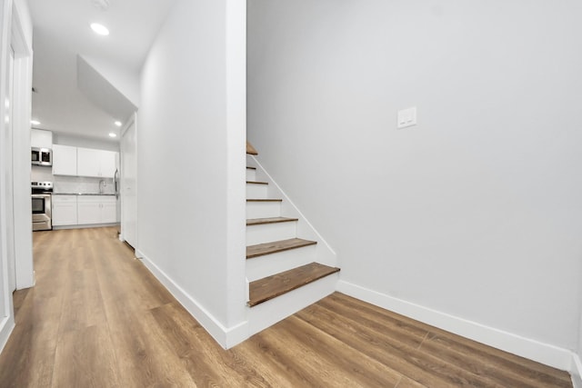 6617 Bacher St, Houston, TX 77028 - stairway featuring wood finished floors, baseboards, and recessed lighting