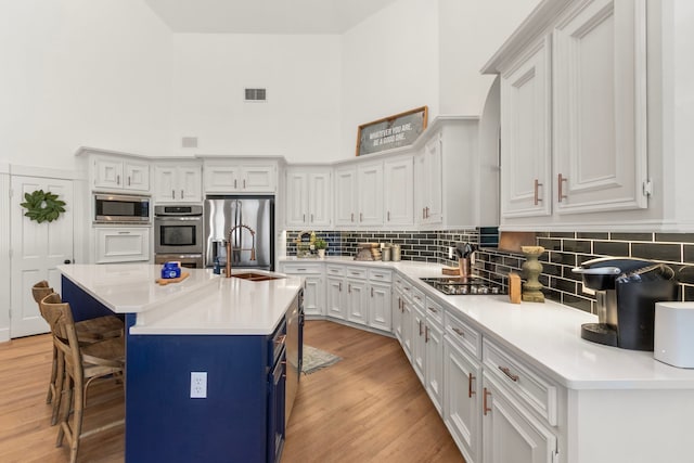 2623 Old S Dr, Richmond, TX 77406 - kitchen featuring a sink, stainless steel appliances, tasteful backsplash, light countertops, and light wood-style floors